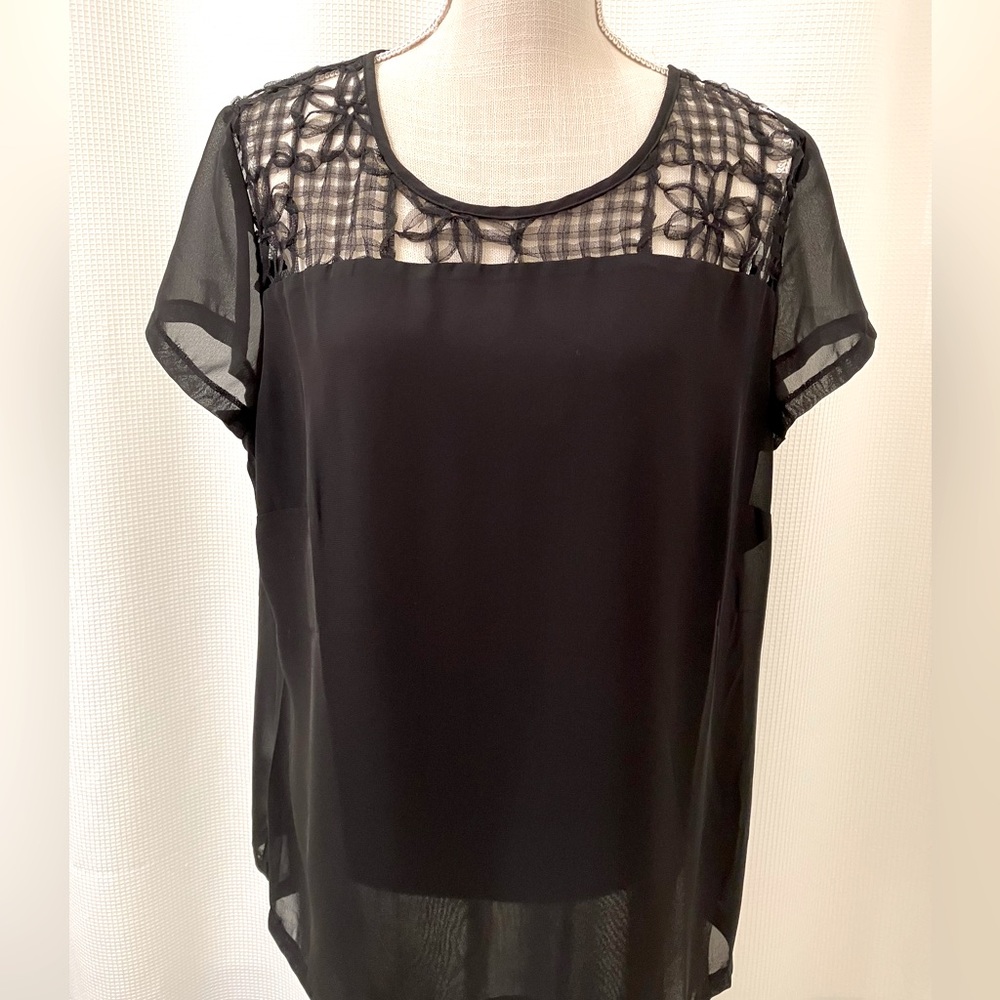 Black top with feminine sheer cutout design across top, est size L
